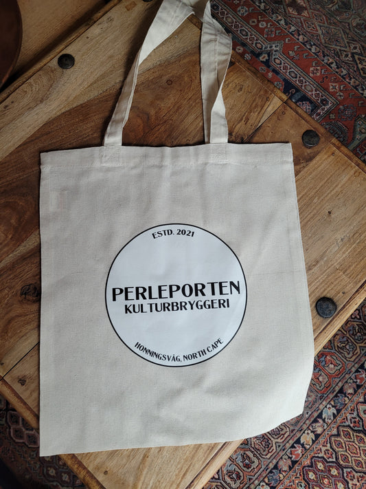 Lys totebag med rund, svart Perleporten Kulturbryggeri-logo