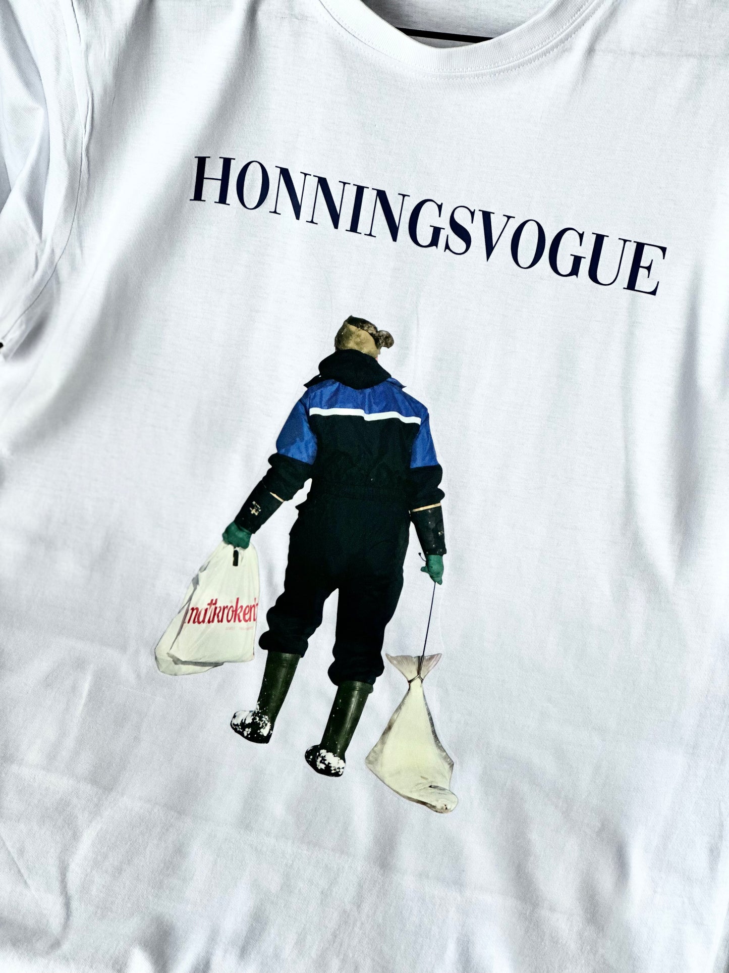 Hvit t-skjorte med HONNINGSVOGUE og fototrykk av en person som går i snøen