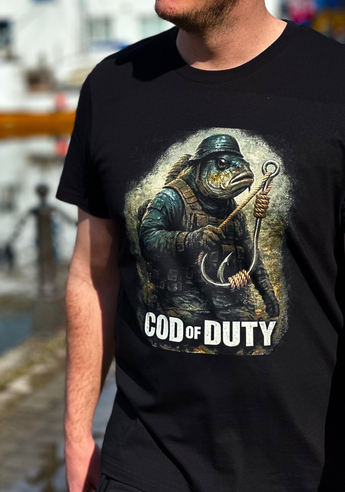 Svart t-skjorte med illustrert fisk i rustning og teksten COD OF DUTY