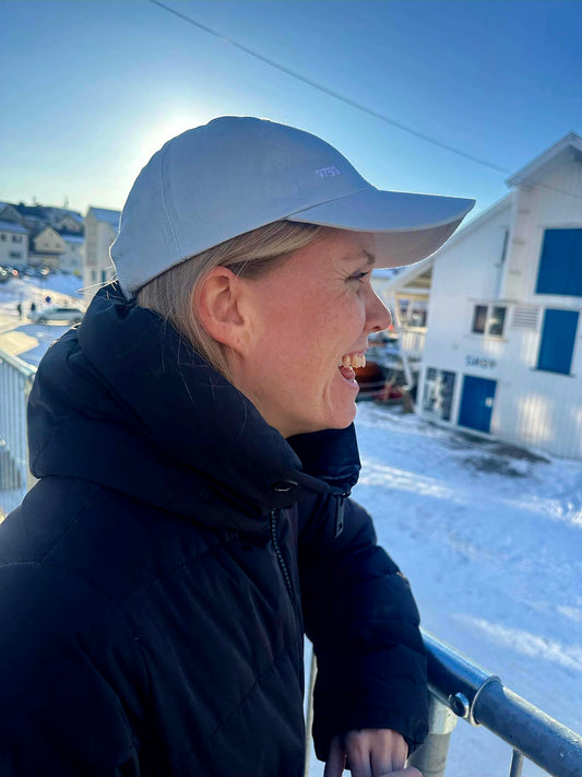 Person med lyseblå caps utendørs i Honningsvåg